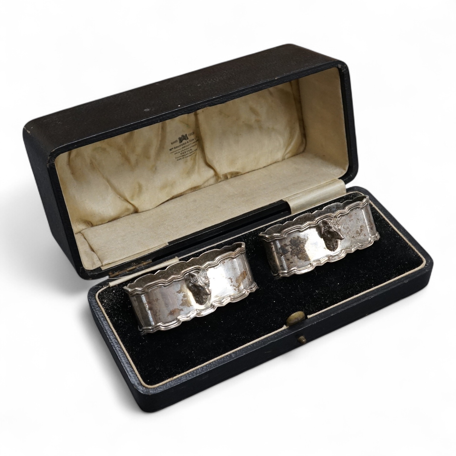 A cased pair of George V silver oval napkin rings, each with a fox head surmount, Adie Brothers, Birmingham, 1928, 72mm.